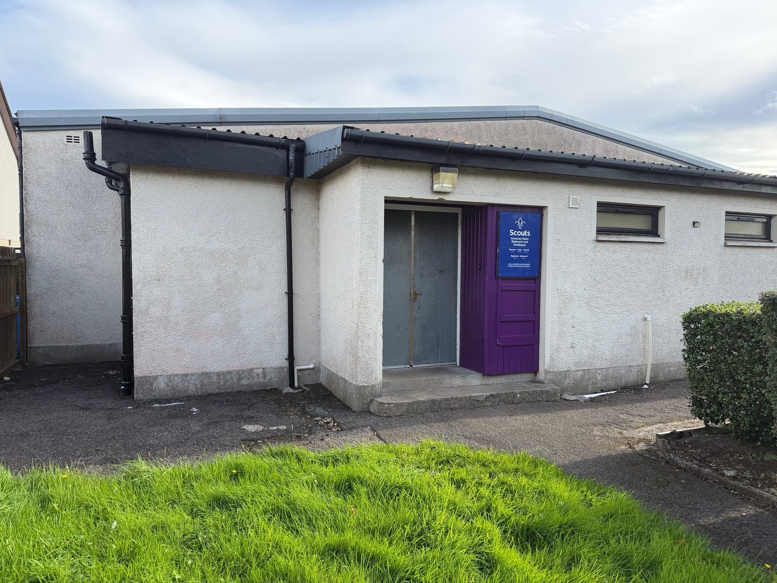 The main entrance to Dalneigh Scout Hall from the street: grey double doors beside a purple panel carrying the Scouts sign.